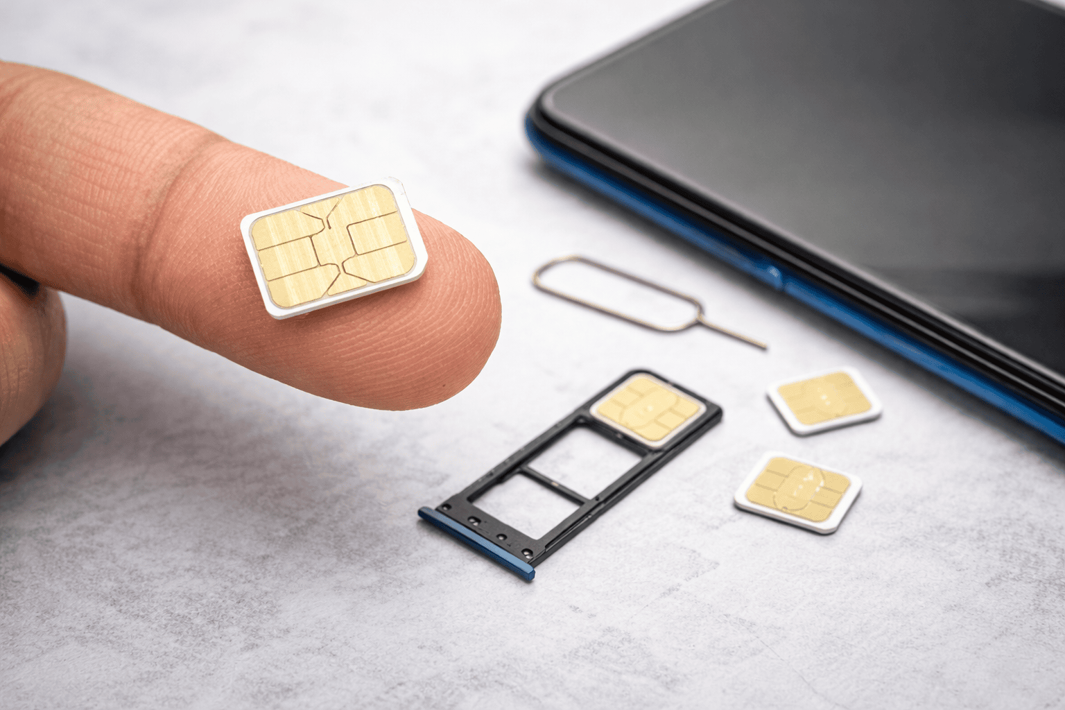 Fyra nano sim kort och en simkortslucka med simkortsverktyg.