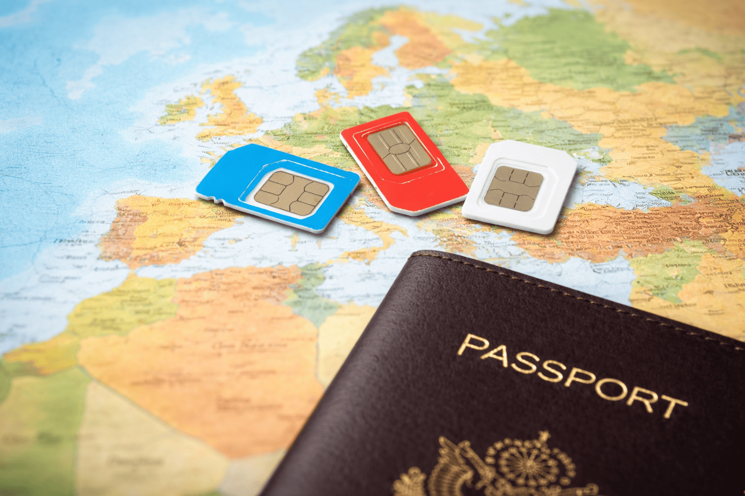 Hur fungerar ett simkort utomlands? Tre simkort och ett pass på en världskarta.
