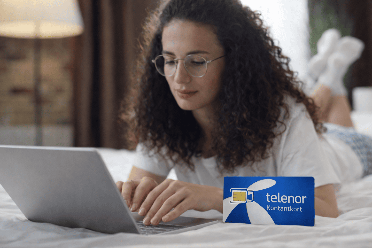 Kvinna som ska köpa simkort med kontantkort från Telenor.